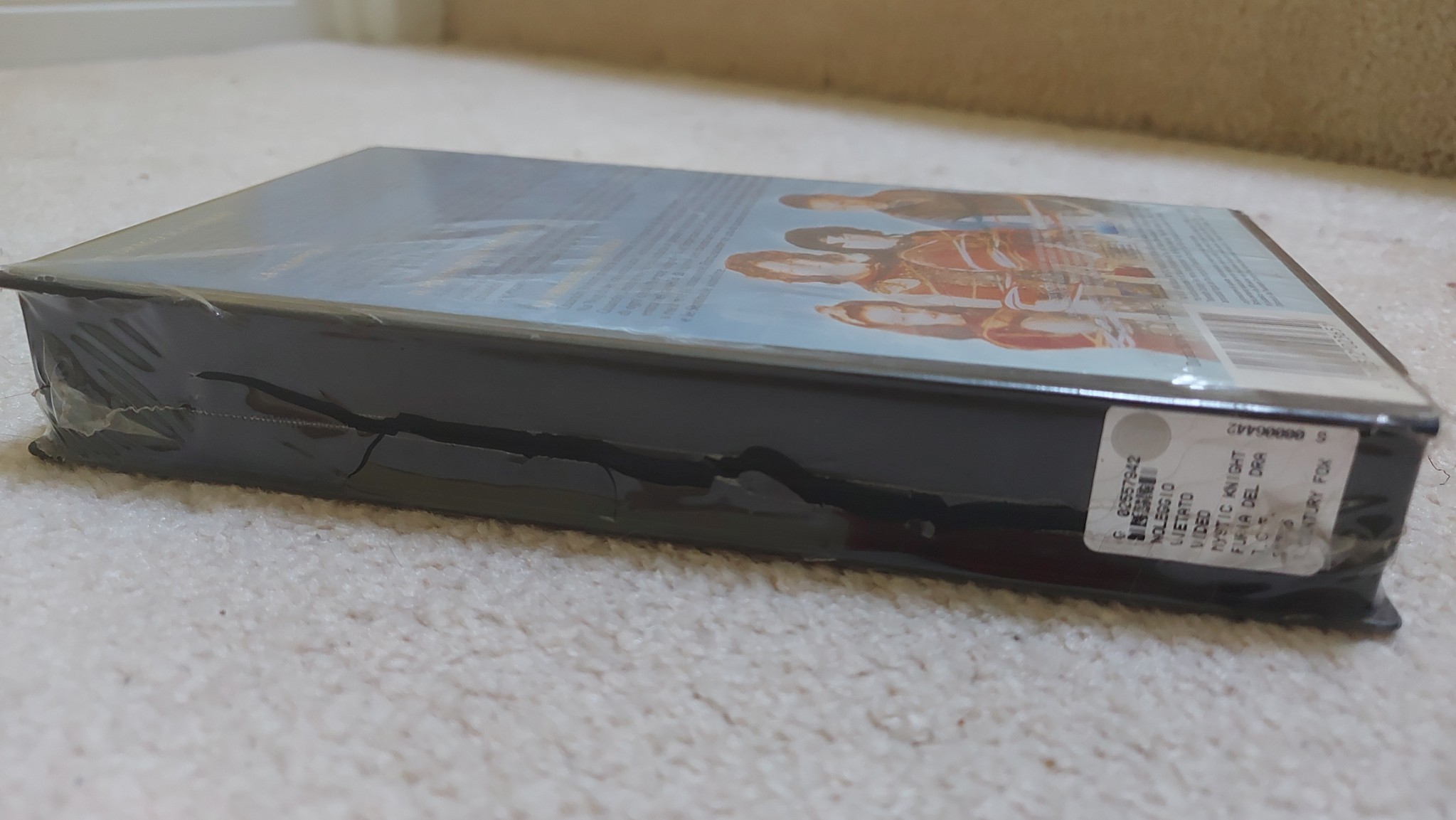 Picture of the side edge of clamsell VHS tape #2 from the Italian home release. The tape is still sealed in its original plastic, which has split due to its age and brittleness.